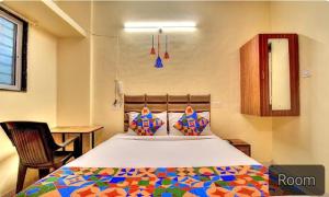 FabExpress SRH Hinjewadi في بيون: غرفة نوم مع سرير كبير مع لحاف ملون