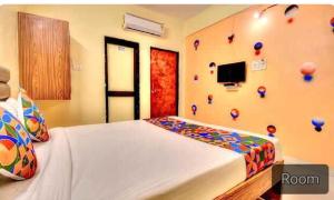 1 dormitorio con 1 cama y una pared decorada en FabExpress SRH Hinjewadi, en Pune