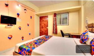 - une chambre avec un lit et une chambre avec un bureau dans l'établissement FabExpress SRH Hinjewadi, à Pune