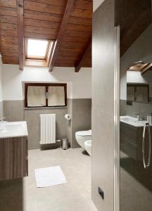 uma casa de banho com um lavatório e um WC em Gorgeous large apartment in mountains em Ballabio