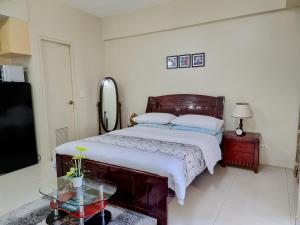 - une chambre avec un lit et une table en verre dans l'établissement One Palm Tree Villas Condo Across NAIA Terminal 3, à Manille