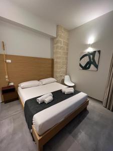 um quarto com uma cama grande com duas toalhas em Egusa73 Favignana em Favignana