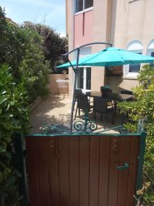 a patio with a table and an umbrella at appartement 6p rez-de-jardin clim accés mer direct in Le Barcarès