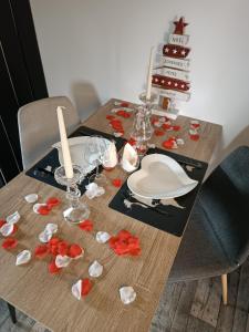 a wooden table with a plate and flowers on it at Maisonnette en bord de rivière tout près du Mans in La Bazoge