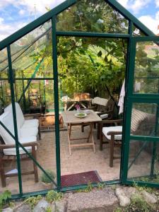 a green gazebo with a wooden table and chairs at Townhouse in Odense