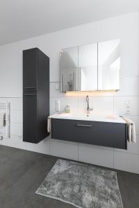 a kitchen with a sink and a mirror at Ferienwohnungen im Haus Deichnest in Bensersiel