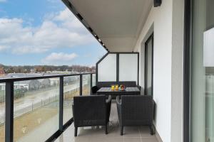 a balcony with a table and chairs and a view at Exclusive Apartment Porta Mare Marina - Swimming Pool & Sauna by Renters Prestige in Dziwnów