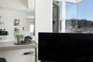 a flat screen tv sitting in a living room with a window at 3 bdr Apt Incredible Acropolis View in Athens