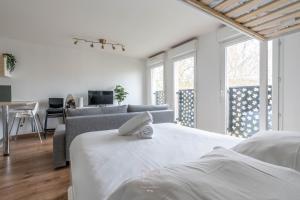Habitación blanca con cama y sofá en *Disneyland-Paris* 5pers Wifi, Parking, Netflix, en Montévrain