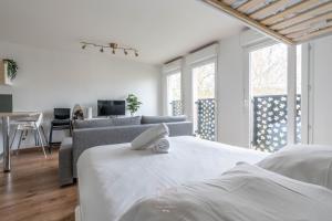 a white bedroom with a bed and a couch at *Disneyland-Paris* 5pers Wifi, Parking, Netflix in Montévrain