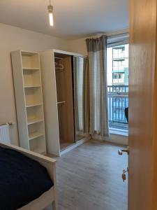 ロンドンにあるLovely room in Modern apartmentのベッドと大きな窓のある寝室