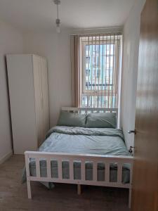 ロンドンにあるLovely room in Modern apartmentのベッドと窓のある小さな寝室