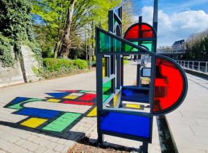 a colorful sign on the side of a sidewalk at Les chambres atypiques de Nico Bush - Parking sécurisé vélos in Tournai