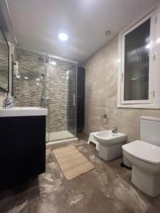 La salle de bains est pourvue d'un lavabo, de toilettes et d'une douche. dans l'établissement Vibes Coruña- Estancia moderna en Eiris, à La Corogne