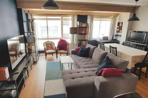 Vibes Coruña- Estancia moderna en Eiris في لا كورونيا: غرفة معيشة مع أريكة وتلفزيون
