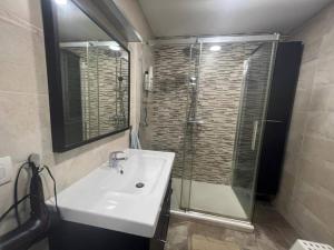 W łazience znajduje się umywalka i przeszklony prysznic. w obiekcie Vibes Coruña- Estancia moderna en Eiris w mieście A Coruña
