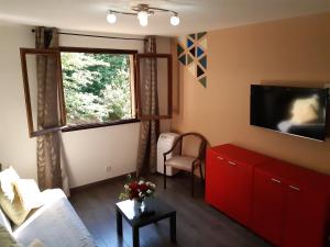 a living room with a red cabinet and a tv at n6 appartement de Vacancorse Maison U Canale in Speloncato