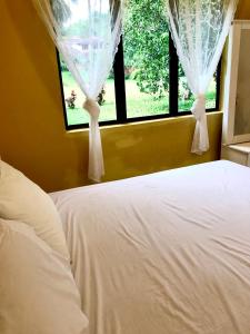 um quarto com uma cama branca e uma janela em Eco Resort Beverly Hills em Ipoh