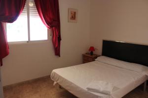 A bed or beds in a room at Delfines II Solo Familias Serviplaya