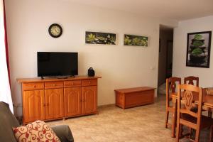 a living room with a flat screen tv on a wooden cabinet at Delfines II Solo Familias Serviplaya in Playa de Xeraco