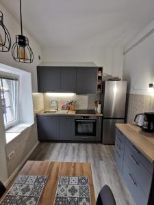eine Küche mit schwarzen Schränken und einem Kühlschrank aus Edelstahl in der Unterkunft Belavita in Bovec