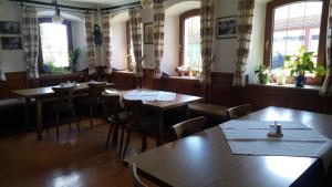 un restaurante con mesas y sillas de madera y ventanas en Gasthaus zum Goldenen Roß en Creglingen