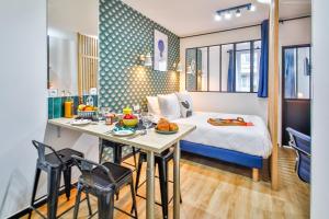 a room with a bed and a table with food on it at WS Hôtel de Ville - Beaubourg in Paris