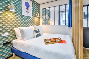 a hotel room with a bed with a tray of food on it at Apartments WS Hôtel de Ville - Beaubourg in Paris