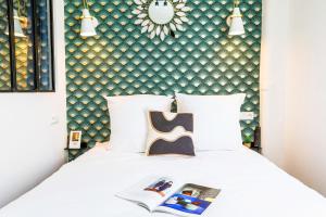 a bedroom with a white bed with a green wall at Apartments WS Hôtel de Ville - Beaubourg in Paris