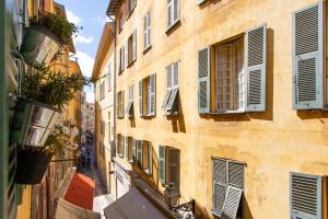 un callejón con ventanas y persianas en un edificio en 26 nice, en Niza