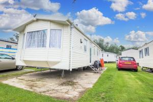 mały domek jest zaparkowany na podwórku w obiekcie Lovely 8 Berth Caravan For Hire At Broadland Sands In Suffolk Ref 20380bs w mieście Hopton on Sea