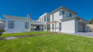 史楚斯灣的住宿－Cliff Haven，一座带绿色草坪的大型白色房屋