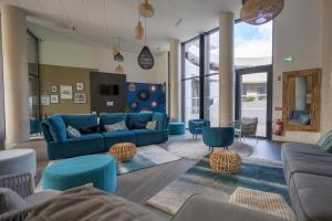 阿格德角的住宿－Résidence Néméa Le Sylène，客厅配有蓝色的沙发和椅子