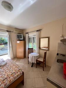 a room with a bed and a table and a kitchen at Studio on the coast, with a view of the sunrise,free we-fi in Kotor