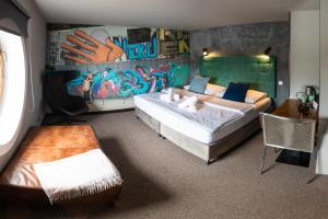 a bedroom with two beds and a graffiti covered wall at Botel Marina in Prague