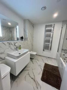 La salle de bains blanche est pourvue d'un lavabo et de toilettes. dans l'établissement Modern Apartment with Spa and Pool, à Gibraltar