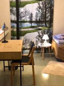 Zimmer mit einem Tisch, einem Bett und einem Fenster in der Unterkunft Tapanilan Huoneistot in Lahti