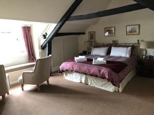 a bedroom with a large bed and a chair at The Royal Oak Inn in Withypool