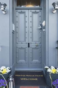a blue door with a welcome sign in front of it at INNit Marina in Brighton & Hove