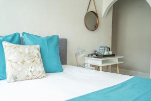 a bedroom with a bed with blue pillows and a mirror at INNit Marina in Brighton & Hove