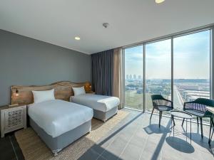 sypialnia z łóżkiem i dużym oknem w obiekcie Emirates Sports Hotel Apartments, Dubai Sports City w Dubaju