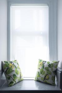 two pillows sitting on a bench in front of a window at INNit Marina in Brighton & Hove