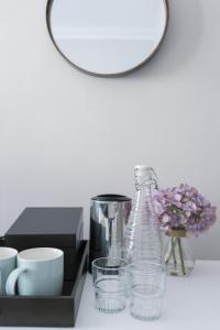 a table with a bottle and cups and a mirror at INNit Marina in Brighton & Hove