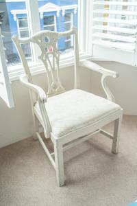 a white chair sitting in front of a window at Brighton Marina House in Brighton & Hove
