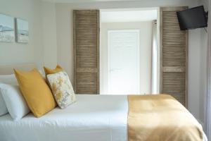 a bedroom with a white bed with yellow pillows at INNit Marina in Brighton & Hove