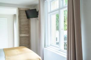 a room with a window and a chair and a television at INNit Marina in Brighton & Hove