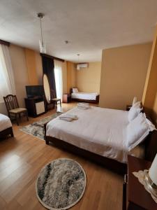 a bedroom with a large bed and a living room at Guesthouse Bimbli in Pogradec