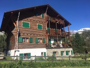 a large wooden house with a balcony on top of it at Stella Alpina sotto al Cervino in Breuil-Cervinia