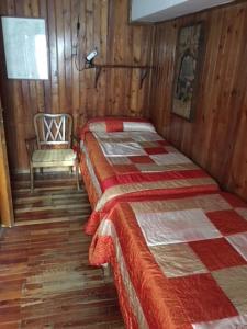 a bedroom with two beds and a chair in a room at Stella Alpina sotto al Cervino in Breuil-Cervinia