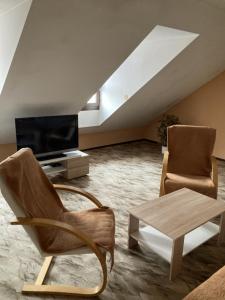 a living room with a couch and a chair and a table at Apartmán Na Ostrově Beroun in Beroun